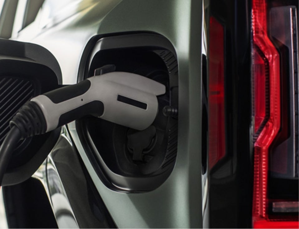 Close up of charging port with charger plugged in on a GMC Hummer EV SUV - Wilkinson GMC in Sanford NC