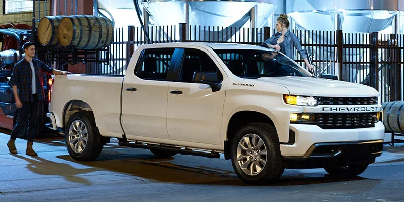 A white Chevrolet Silverado pickup truck parked in an industrial setting.
